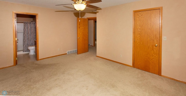 unfurnished bedroom featuring a textured ceiling, ceiling fan, light colored carpet, and ensuite bathroom