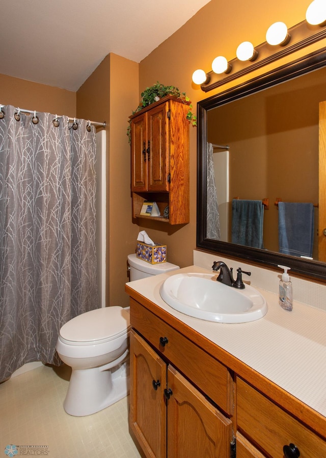 bathroom featuring toilet, vanity, curtained shower, and tile patterned floors