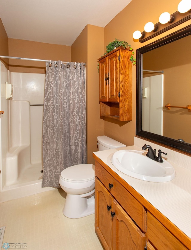 bathroom with tile patterned flooring, toilet, a shower with shower curtain, and vanity