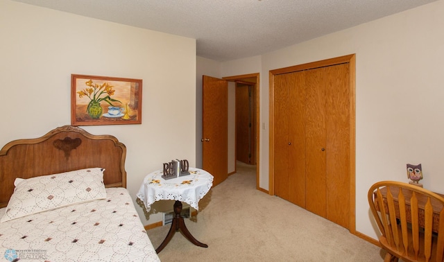 carpeted bedroom with a closet and a textured ceiling