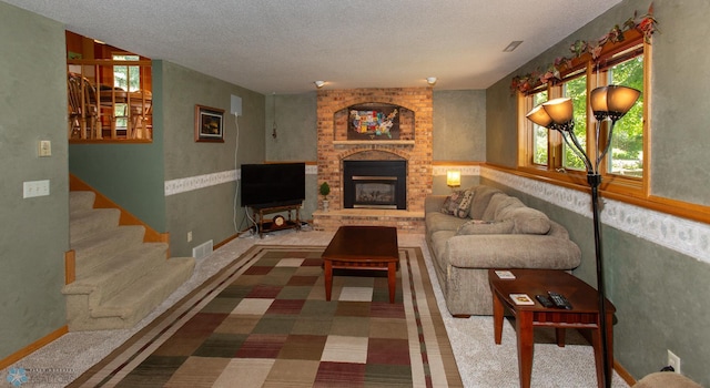 living room featuring a textured ceiling, brick wall, and a brick fireplace