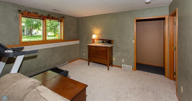 interior space featuring a textured ceiling, baseboard heating, and light carpet