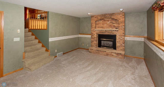 unfurnished living room featuring a fireplace, a textured ceiling, and carpet floors