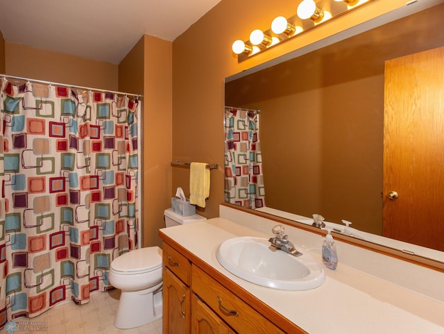 bathroom featuring tile patterned flooring, toilet, and vanity