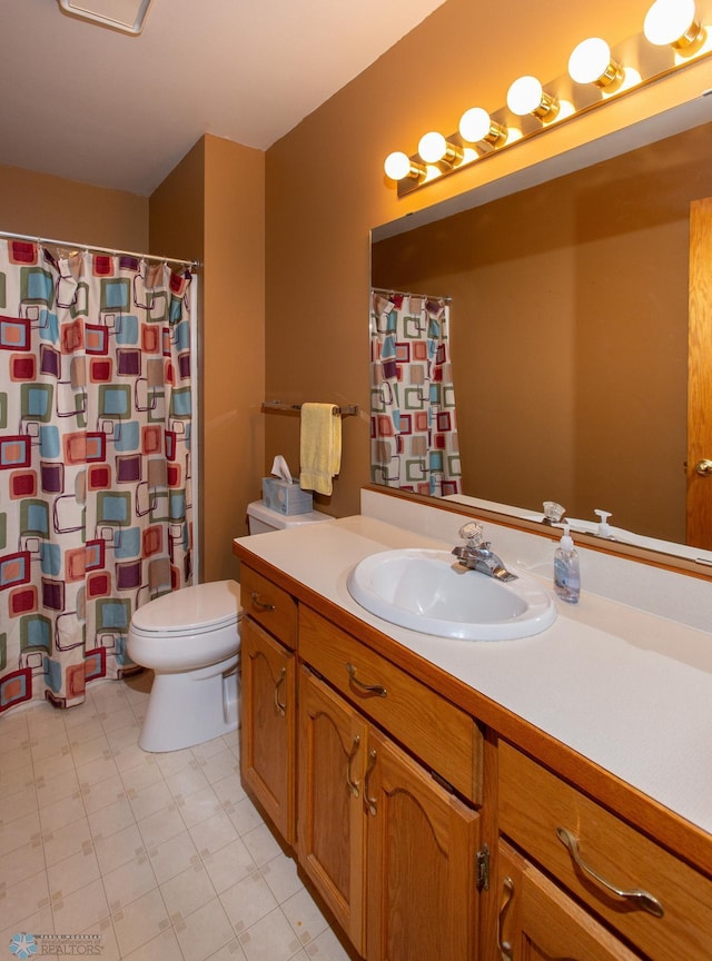 bathroom with tile patterned flooring, toilet, and vanity