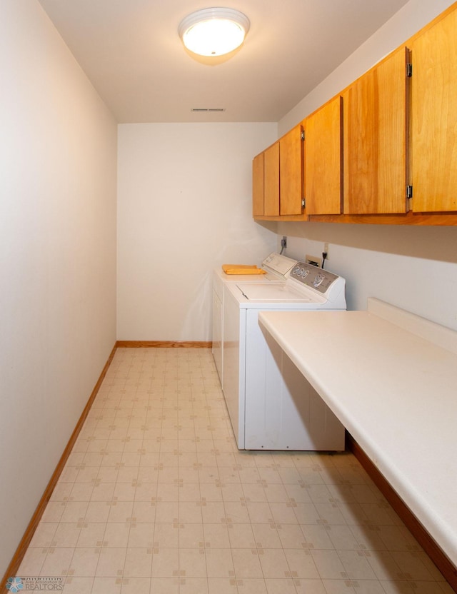 clothes washing area with independent washer and dryer, cabinets, and light tile patterned flooring