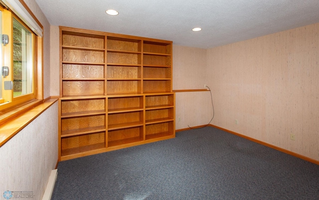 carpeted empty room with a textured ceiling