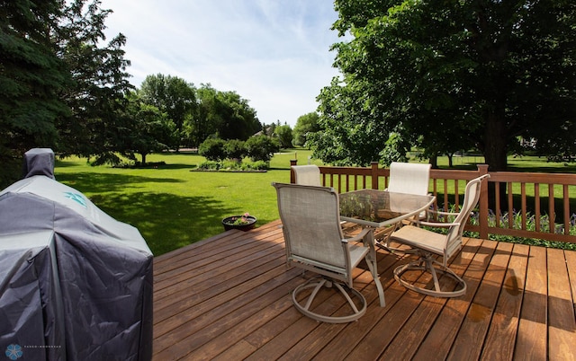 wooden deck featuring grilling area and a lawn