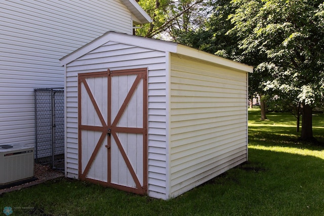 view of outbuilding with central AC unit and a yard