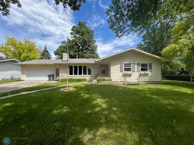 single story home featuring a garage and a front yard