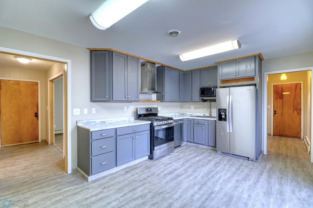 kitchen featuring light hardwood / wood-style floors, stainless steel appliances, gray cabinetry, wall chimney exhaust hood, and sink