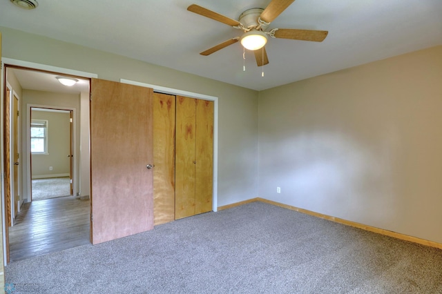 unfurnished bedroom with ceiling fan, a closet, and hardwood / wood-style flooring