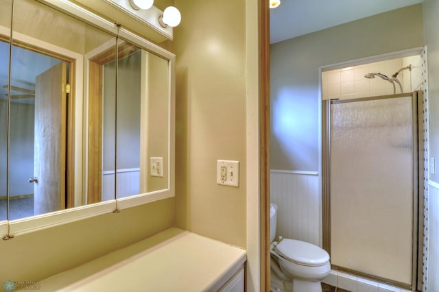 bathroom with a shower with door, toilet, and vanity