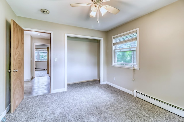 unfurnished bedroom featuring a closet, ceiling fan, carpet floors, and a baseboard radiator