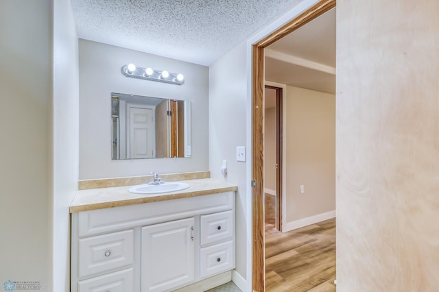 bathroom featuring wood-type flooring, a textured ceiling, and vanity