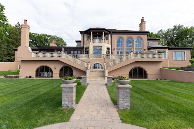 exterior space featuring a front lawn and a balcony