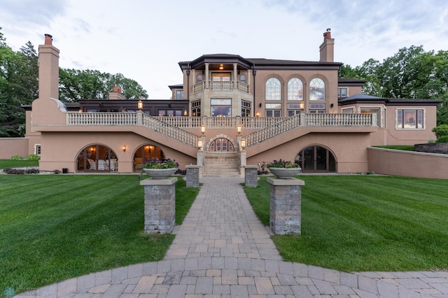 view of front of home with a front yard and a balcony