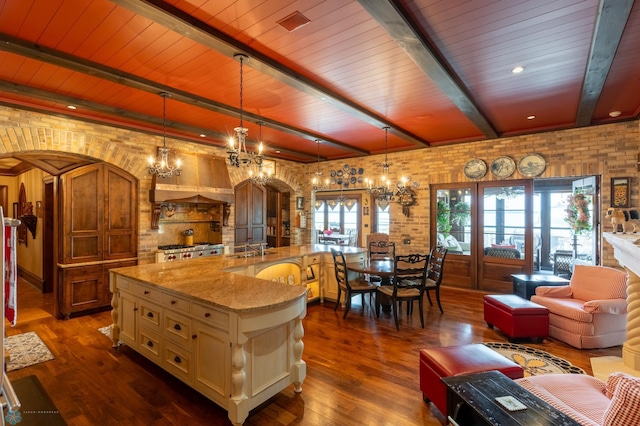 kitchen featuring wooden ceiling, hanging light fixtures, light stone countertops, and an inviting chandelier