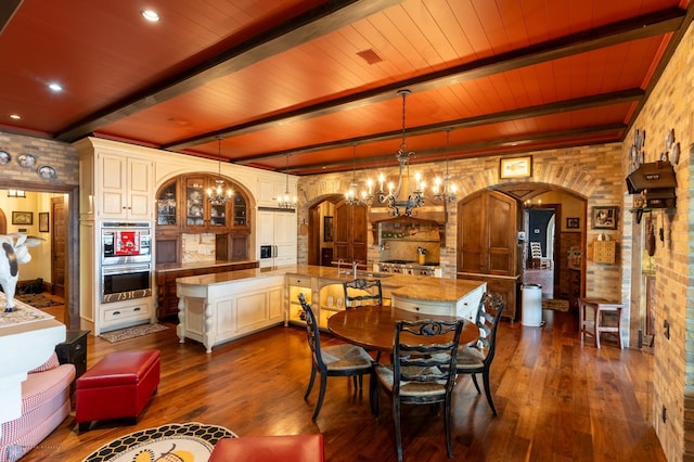 dining area featuring beam ceiling, wooden ceiling, dark wood-type flooring, and a notable chandelier