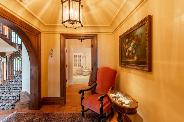 sitting room featuring tile floors, crown molding, and a chandelier