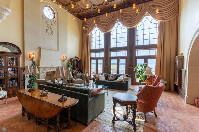 living room with a towering ceiling, tile flooring, wood ceiling, and coffered ceiling