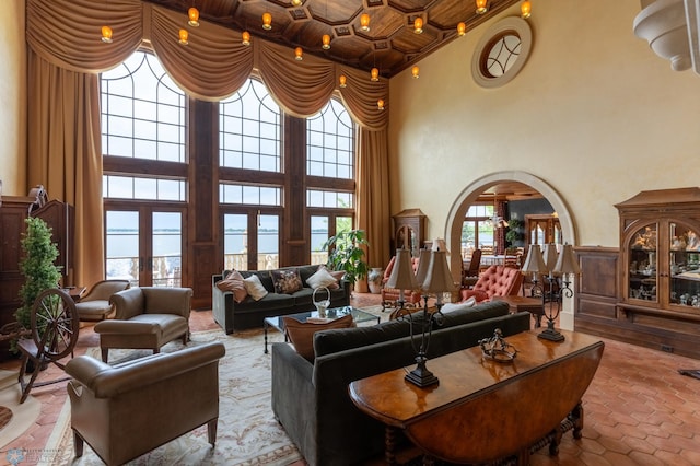 living room with a high ceiling and a healthy amount of sunlight