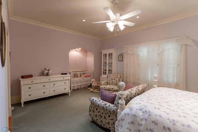 bedroom with ornamental molding, dark colored carpet, and ceiling fan