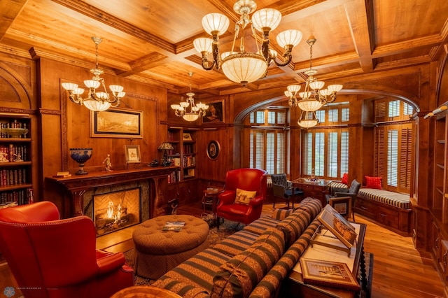 living room featuring coffered ceiling, hardwood / wood-style floors, wood walls, and a chandelier