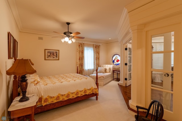 carpeted bedroom featuring ceiling fan and crown molding