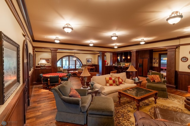 living room featuring wood-type flooring, decorative columns, and crown molding