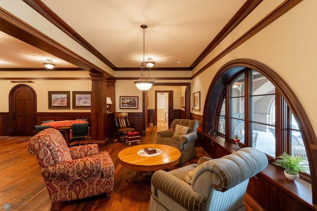 living room featuring a healthy amount of sunlight, hardwood / wood-style flooring, and decorative columns