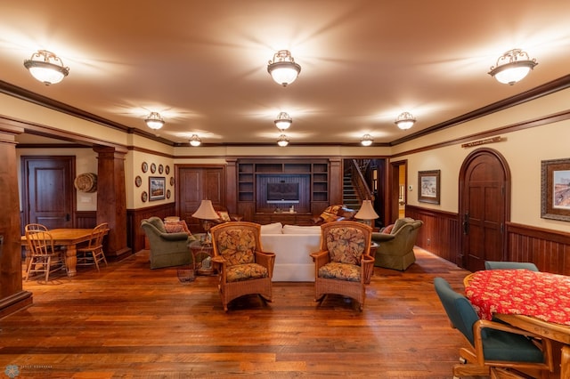 living room featuring ornamental molding, hardwood / wood-style floors, and decorative columns