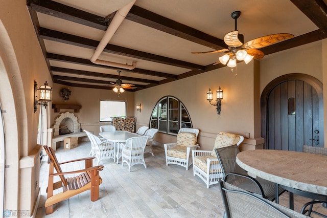 dining area featuring ceiling fan, beam ceiling, and light hardwood / wood-style flooring