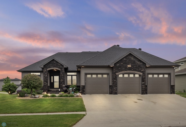 view of front of property with a garage and a lawn