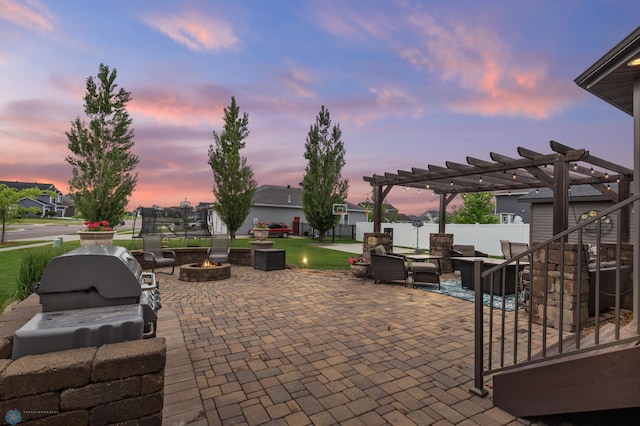 patio terrace at dusk with a pergola and a fire pit