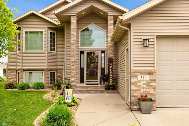 property entrance featuring a garage and a lawn