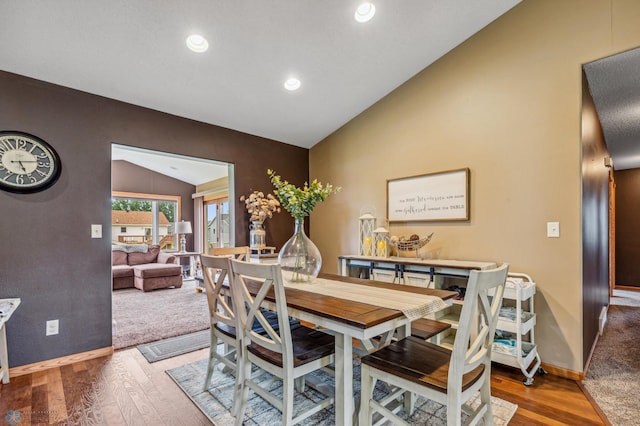 dining area with wood-type flooring and lofted ceiling