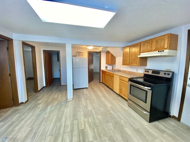 kitchen with light hardwood / wood-style floors, a textured ceiling, white refrigerator, and stainless steel electric range oven