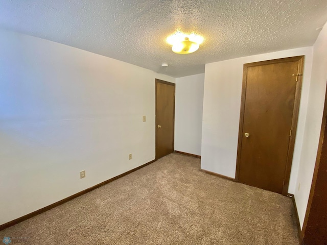 unfurnished bedroom featuring carpet, a closet, and a textured ceiling