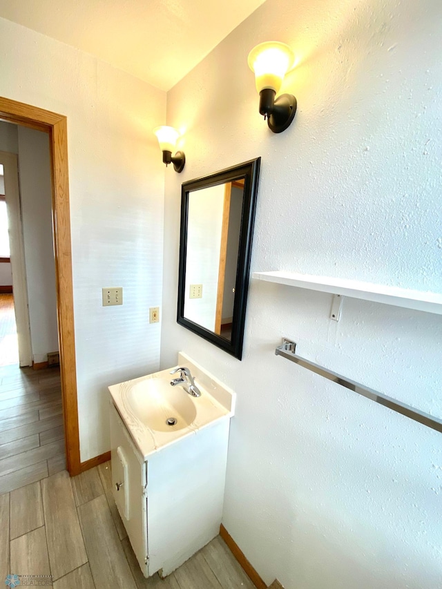 bathroom with vanity with extensive cabinet space and hardwood / wood-style flooring