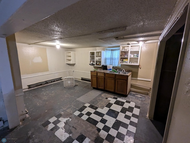 basement featuring tile floors, a textured ceiling, and sink