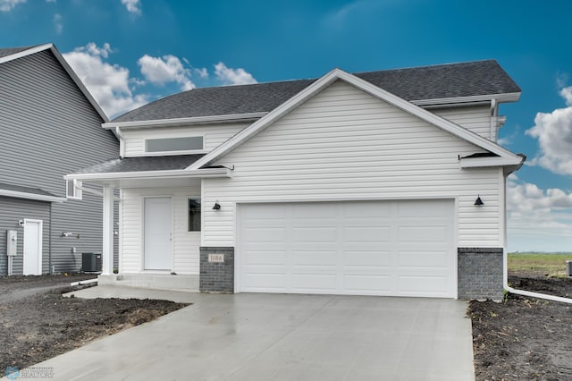 view of front property featuring a garage and central air condition unit