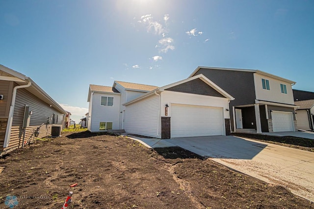 view of front of house with a garage and central air condition unit