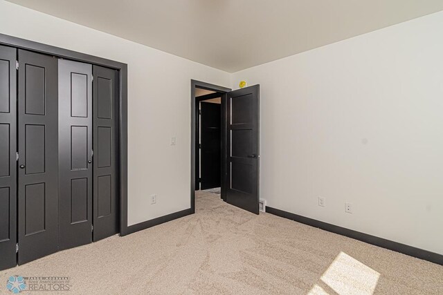 unfurnished bedroom featuring carpet flooring and a closet