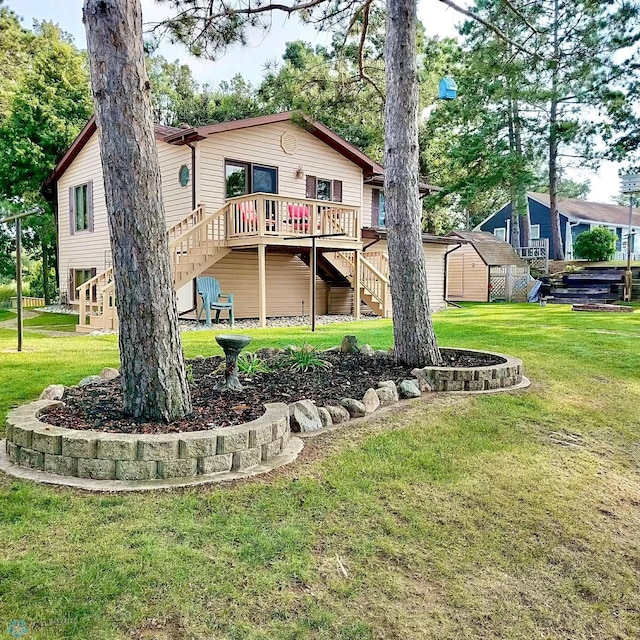 back of house featuring a storage shed, a yard, and a wooden deck