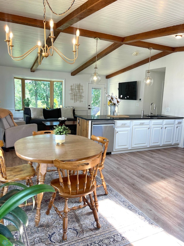 dining space with sink, an inviting chandelier, vaulted ceiling with beams, and light hardwood / wood-style flooring