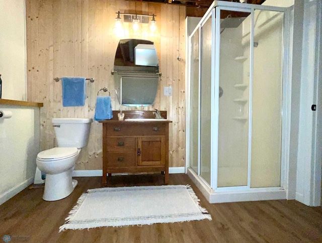 bathroom with vanity, a shower with shower door, hardwood / wood-style floors, and toilet