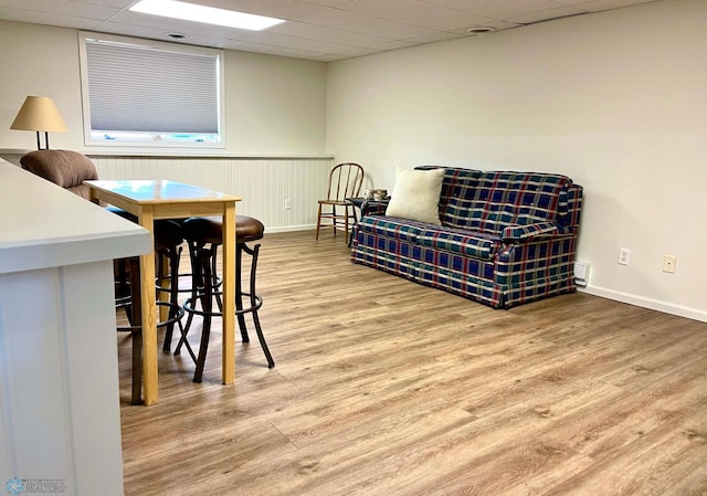 sitting room with light wood-type flooring and a drop ceiling