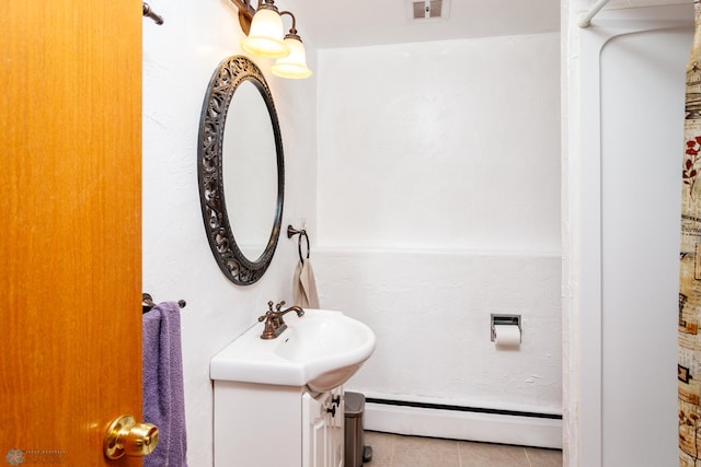 bathroom with tile flooring, baseboard heating, and vanity