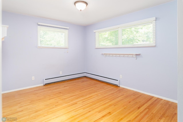 spare room with plenty of natural light, light wood-type flooring, and baseboard heating